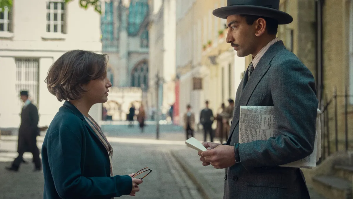 A man and a young woman stand opposite each other talking in the street