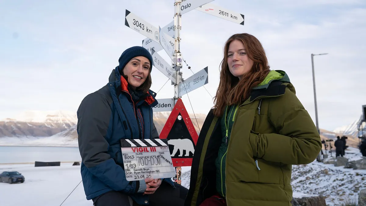 Suranne Jones and Rose Leslie in the Artic holding a clapperboard
