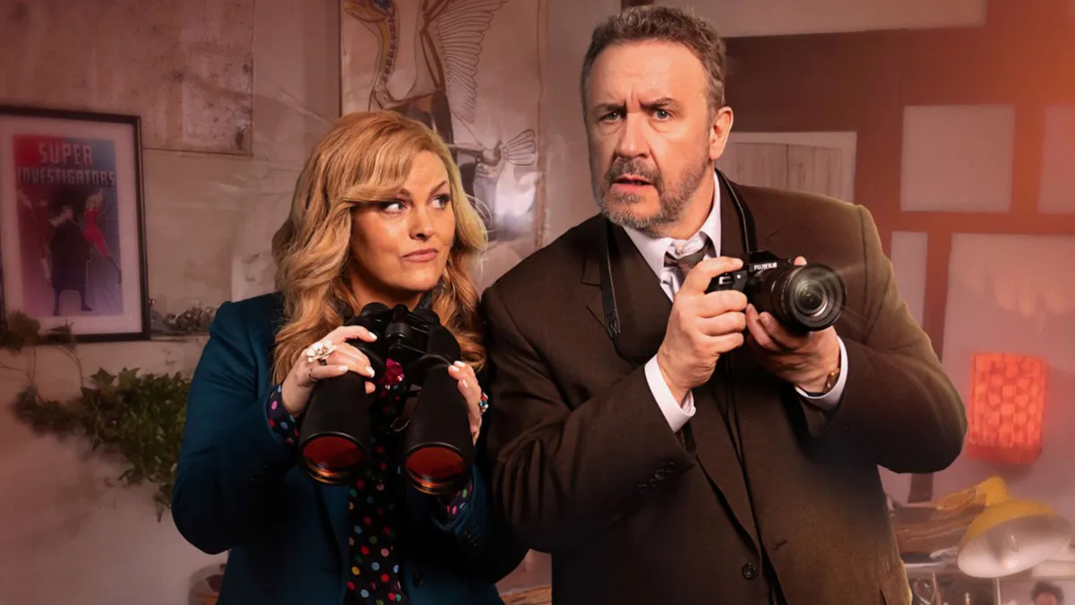 Jo Joyner and Mark Benton pose with cameras for Shakespeare & Hathaway's key art
